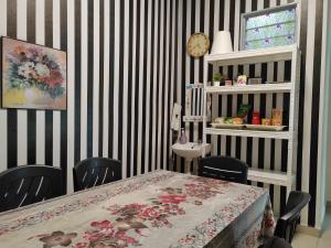 Teratak Delisha -musslim في Kampong Jemampar: غرفة طعام بطاولة وشرائط سوداء وبيضاء