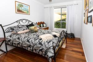 um quarto com uma cama em preto e branco e uma janela em Rakali's View - 7 Wetlands Close em Murray Bridge