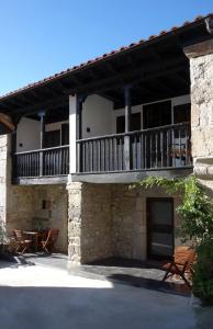 a building with a balcony and a patio at Belenos Alojamientos Turísticos in Niembro