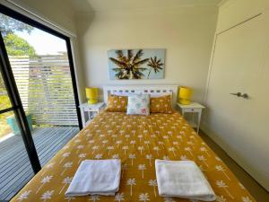 a bedroom with a bed and a large window at Sea Breeze on Carroll - 4BR beachside home in Mollymook