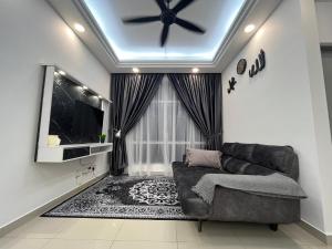 ein Wohnzimmer mit einem Sofa und einem Deckenventilator in der Unterkunft TZ’s Homestay Seremban in Seremban