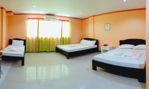 a room with two beds and a yellow curtain at RedDoorz @ Johsons Pension House Butuan City in Butuan
