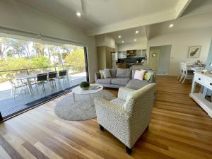 a living room with a couch and a table at Sea Breeze on Carroll - 4BR beachside home in Mollymook