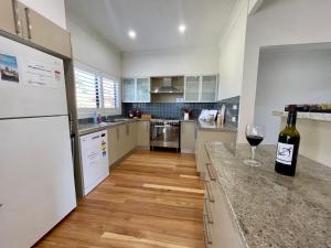 a kitchen with a bottle of wine on a counter at Sea Breeze on Carroll - 4BR beachside home in Mollymook