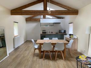 Una cocina y un comedor con mesa y sillas de madera. en Gîte de Corsas, en Saint-Victor