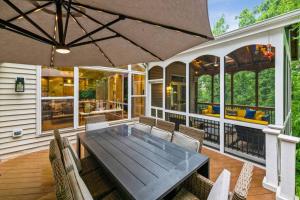 a patio with a table and chairs and an umbrella at Luxury Retreat with Family Feel: Perfect Getaway! in Leesburg