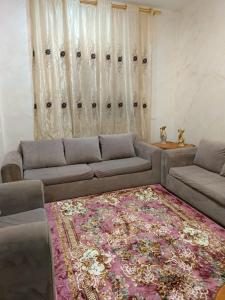 a living room with a couch and a rug at Traveler's house in Jerash