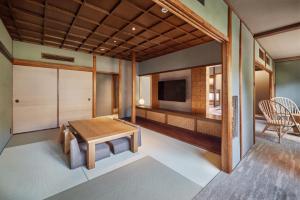 a living room with a table and a television at The Villa Nene-no-Michi Kazeno Heritage formerly HOTEL VMG RESORT KYOTO Nene in Kyoto