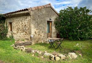 uma mesa de piquenique em frente a um edifício de pedra em Gîte de Corsas em Saint-Victor