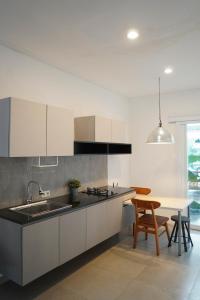 a kitchen with a sink and a table with chairs at No303 in Bandung