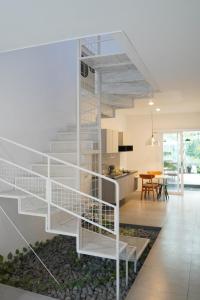 a white staircase in a living room with a kitchen at No303 in Bandung