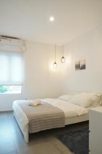 a white bedroom with a large bed in it at No303 in Bandung