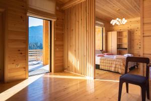 a bedroom with a bed and a large window at Svaneti Countryside 5 in Mestia