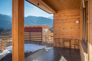 a room with a table and chairs on a balcony at Svaneti Countryside 5 in Mestia