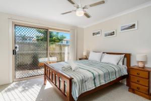 a bedroom with a bed and a large window at The Terrace in East Ballina