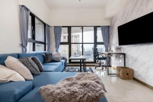 a living room with a blue couch and a tv at High Floor New Bldg 4B2bLDK Ximending, Stunning Views • 高層新樓 4房2衛 西門町 美景 in Taipei