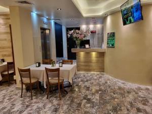 una sala da pranzo con tavoli, sedie e TV di Hotel Cristal a Poza Rica de Hidalgo