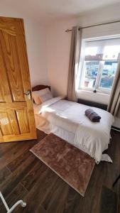 a bedroom with a bed next to a window at Roofers Rest in Magherafelt +5 photos