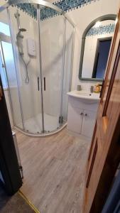 a bathroom with a shower and a sink and a mirror at Roofers Rest in Magherafelt