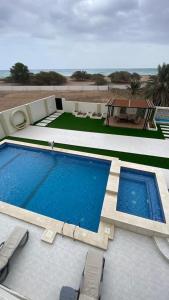 a large swimming pool with chairs and a table at دار الضباب dar al dhabab 