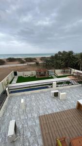 un patio con bancos y vistas a la playa en دار الضباب dar al dhabab 