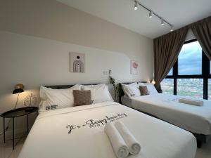 2 weiße Betten in einem Zimmer mit Fenster in der Unterkunft HighPark Suites by Sleepy Bear in Petaling Jaya