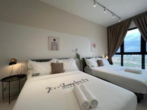 two white beds in a room with a window at HighPark Suites Kelana Jaya, Petaling Jaya by Sleepy Bear in Petaling Jaya