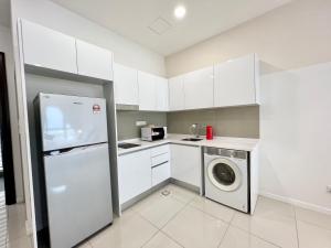 a kitchen with white cabinets and a washer and dryer at HighPark Suites Kelana Jaya, Petaling Jaya by Sleepy Bear in Petaling Jaya