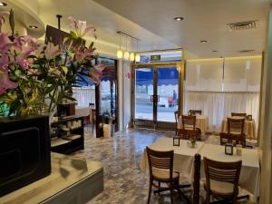 um restaurante com mesa, cadeiras e flores em Hotel Cristal em Poza Rica de Hidalgo