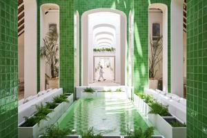 貝爾馬爾的住宿－LUX* Belle Mare Resort & Villas，绿色瓷砖建筑的大堂 ⁇ 染