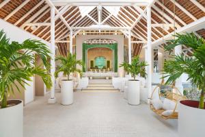 a hallway with palm trees in a building at LUX* Belle Mare Resort & Villas in Belle Mare