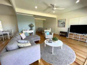 a living room with a couch and a table at Sea Breeze on Carroll - 4BR beachside home in Mollymook