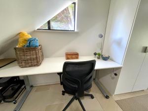 a desk in a room with a chair and a window at Sea Breeze on Carroll - 4BR beachside home in Mollymook