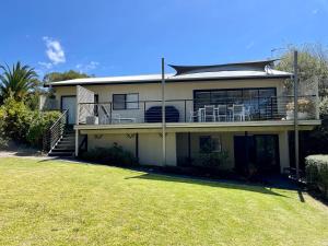 a large house with a lawn in front of it at Sea Breeze on Carroll - 4BR beachside home in Mollymook