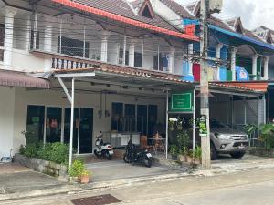 un bâtiment avec deux motos garées devant lui dans l'établissement MEGIE HOMESTAY Premier Betong Thailand, à Betong
