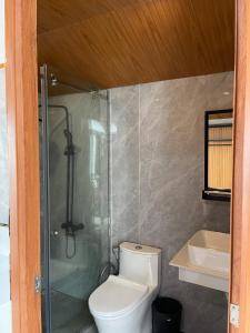 La salle de bains est pourvue de toilettes, d'une douche et d'un lavabo. dans l'établissement Meta Sea, à Nam Du