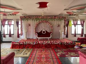 a large room with a red bed and a curtain at Hotel Pratap Palace in Bharatpur