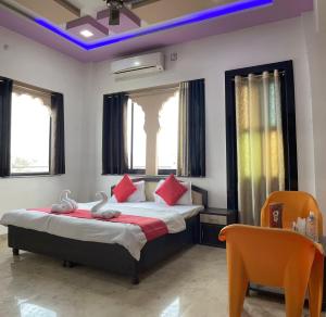 a bedroom with a bed with red pillows at Hotel Pratap Palace in Bharatpur