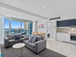 a living room with two couches and a kitchen at H-Residences - Gclr in Gold Coast