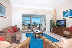 a living room with a couch and a tv at Quarterdeck 5 in Lennox Head