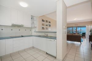 a kitchen with white cabinets and a dining room at Quarterdeck 5 in Lennox Head