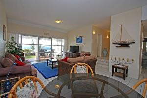 a living room with a glass table and chairs at Quarterdeck 5 in Lennox Head +4 photos