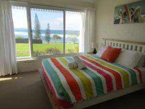 a bedroom with a bed with a view of the ocean at Quarterdeck 5 in Lennox Head