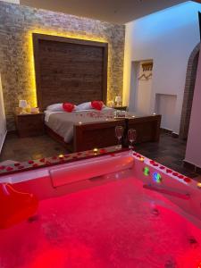 a bedroom with a large bed and a tub with red lights at “La Casetta nel Borgo” in Cerveteri