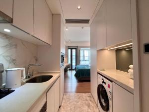 a kitchen with a sink and a washer and dryer at Kaisen Xiyue Hotel Apartment - Shenzhen International Convention and Exhibition Center in Shenzhen