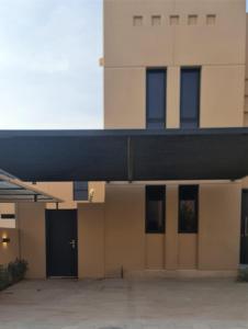 un edificio con un estacionamiento delante de él en Sidrah House en Riad