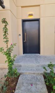 una puerta negra en un edificio con unas escaleras en Sidrah House en Riad