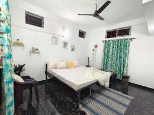 a bedroom with a bed and a ceiling fan at Nimo Homes in Kāziranga