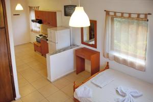 a small kitchen with a bed and a refrigerator at Hotel Geromichalos in Paralía Skotínis