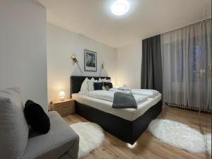 sypialnia z dużym łóżkiem i kanapą w obiekcie Appartements Slishani 2 w mieście Sankt Michael im Lungau